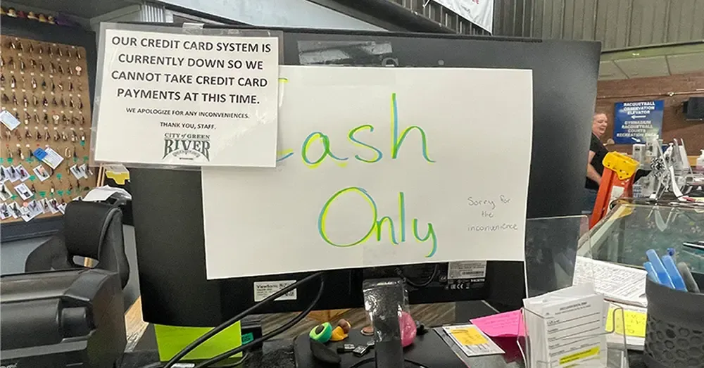 A hand-written "Cash Only" sign taped to a computer monitor at the Green River Recreation Center, informing patrons of a payment system outage following a ransomware attack.