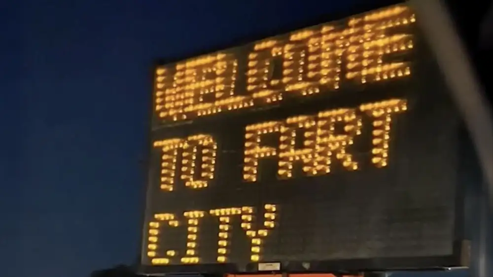 Electronic roadside sign at night showing the message “WELCOME TO FART CITY,” indicating it has been manually reprogrammed.