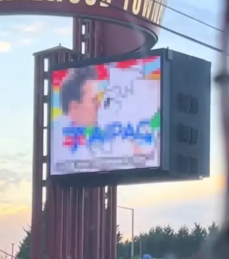 Censored image on a large outdoor digital billboard at Lakewood Towne Center in Lakewood, Washington, photographed at dusk after an apparent hack.