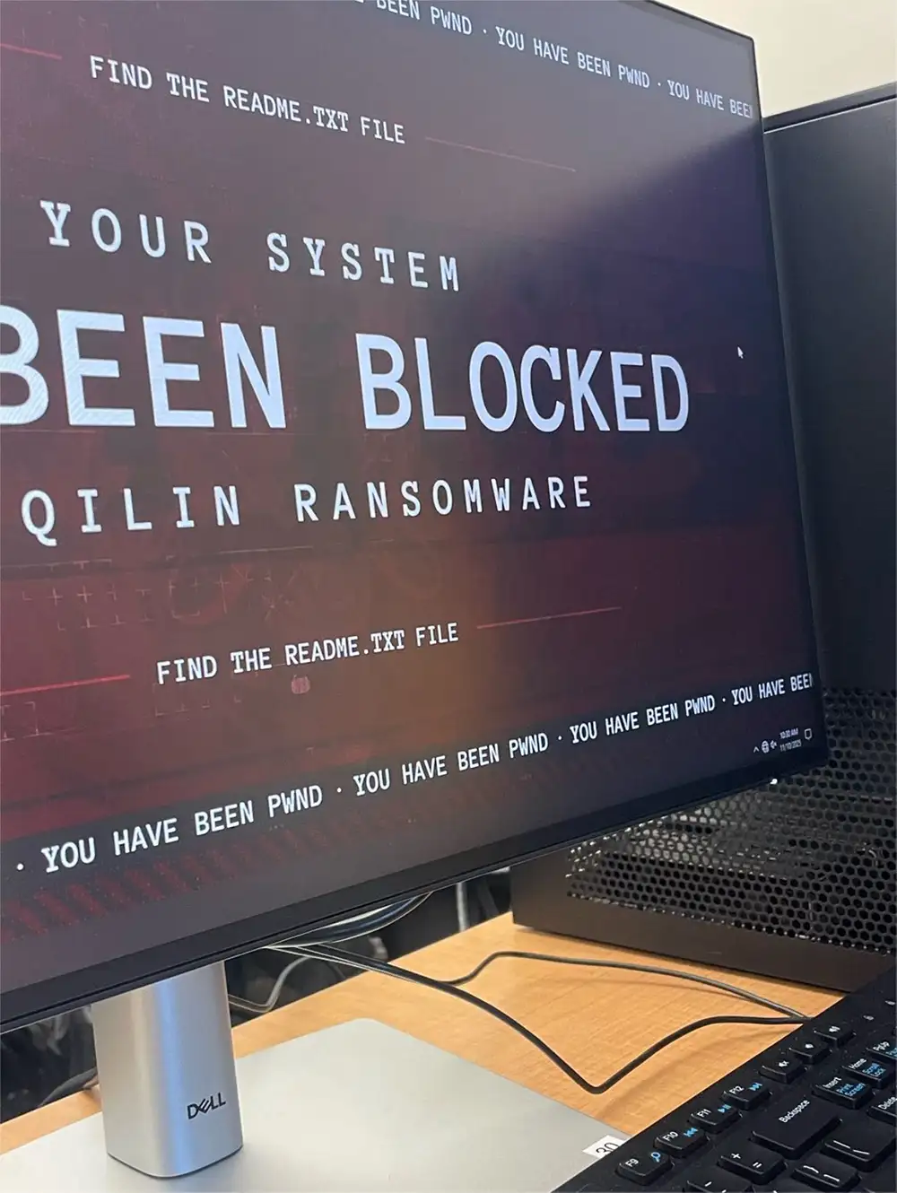 Dell monitor in an LSSU computer lab displaying a red ransomware lock screen with the words “Your system has been blocked” and “Find the README.TXT file,” keyboard and tower visible.