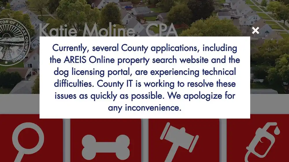 Screenshot of a Lucas County Auditor website alert stating the AREIS property search site and dog licensing portal are having technical difficulties.