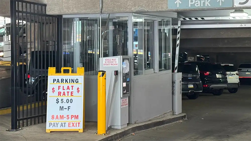 Sign advertising $5 flat-rate parking beside a kiosk at York’s Philadelphia Street parking garage, where drivers paid manually during the 2025 system outage.