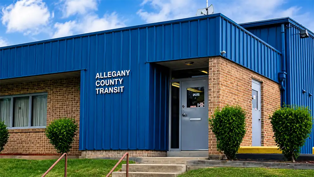 Allegany County Transit building in Cumberland, Maryland, with blue metal siding and a sign near the entrance.