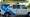 White-and-blue Spectrum installation van with roof ladders parked under trees; large “Spectrum” logo on the side.