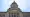 Front view of the Washington State Capitol Legislative Building in Olympia, Washington, showing wide stone steps leading up to tall columns and a large dome against a light blue sky.