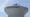 Close-up of a white Plymouth, Minnesota, water tower with the city name and logo painted near the top and cellular antennas mounted on the roof.