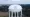 A large white Coweta County Water and Sewerage Authority water tower rises above a wooded area in Coweta County, Georgia.