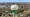 A white and green water tower labeled “Brown City” rises above homes and trees in Brown City, Michigan.