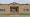 Brick administration building with “Dennis R. Hill Administration Building, Llano ISD” above glass entrance doors, with steps and an access ramp.